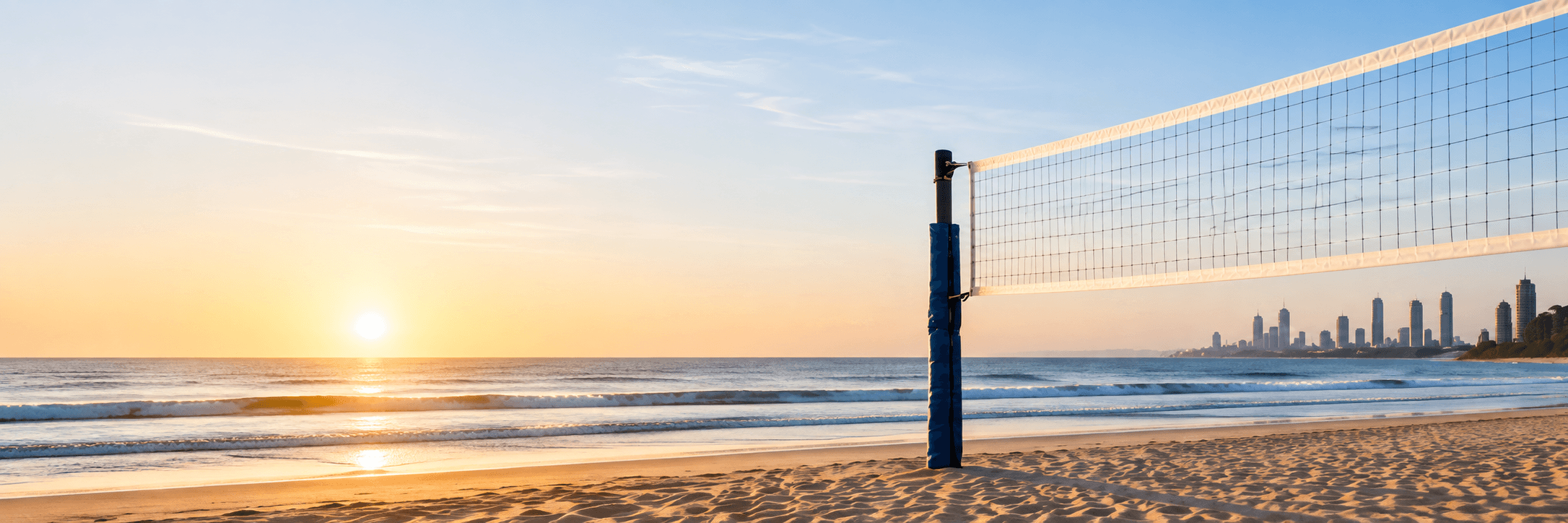 Beach volleyball net beside the ocean at sunset
